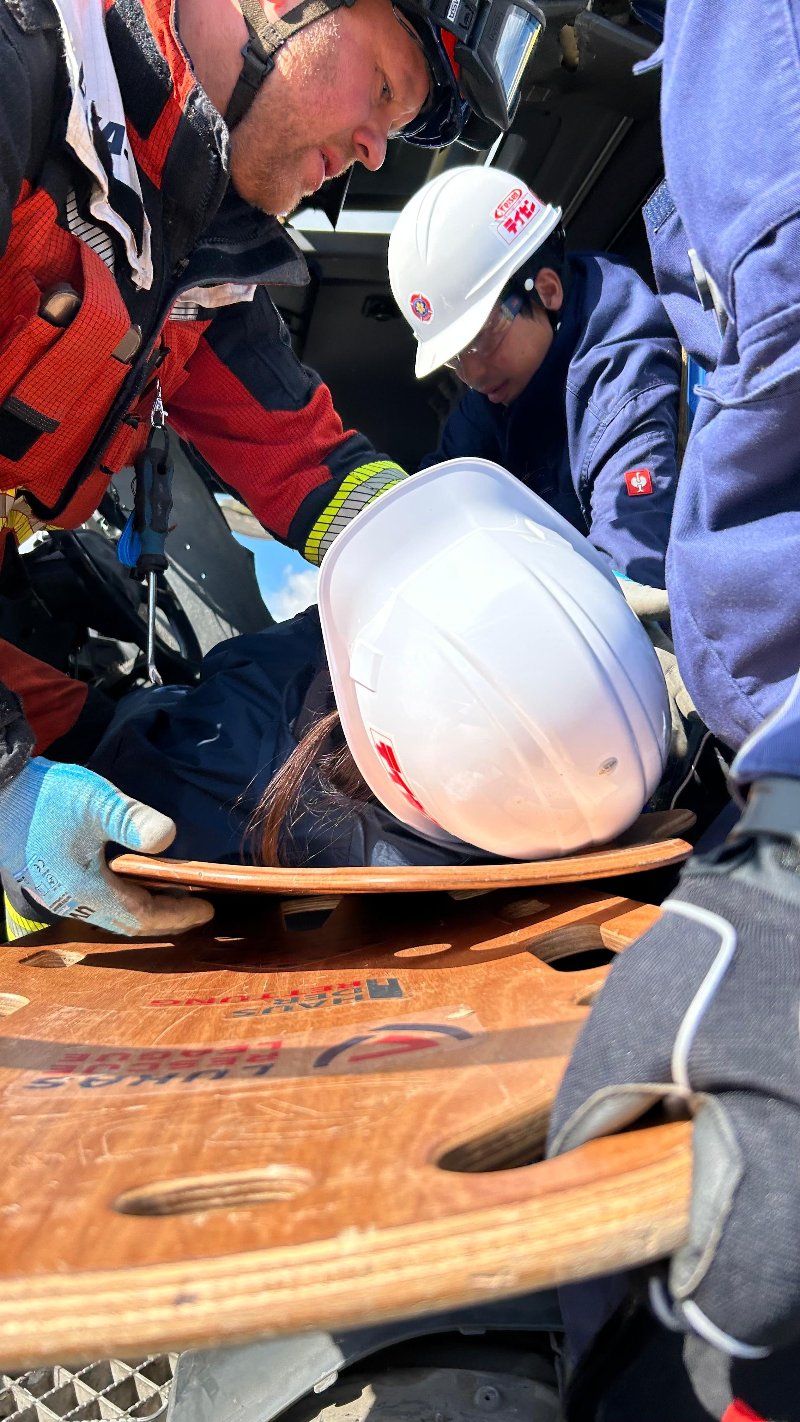 Unfallopfer wird mit dem Shortboard von Haus der Rettung aus engem Fahrzeug geholt.